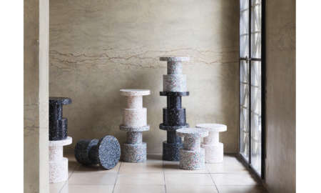 Grouped Bit Stools in black, white, and blue finishes arranged in a styled interior beside a window.